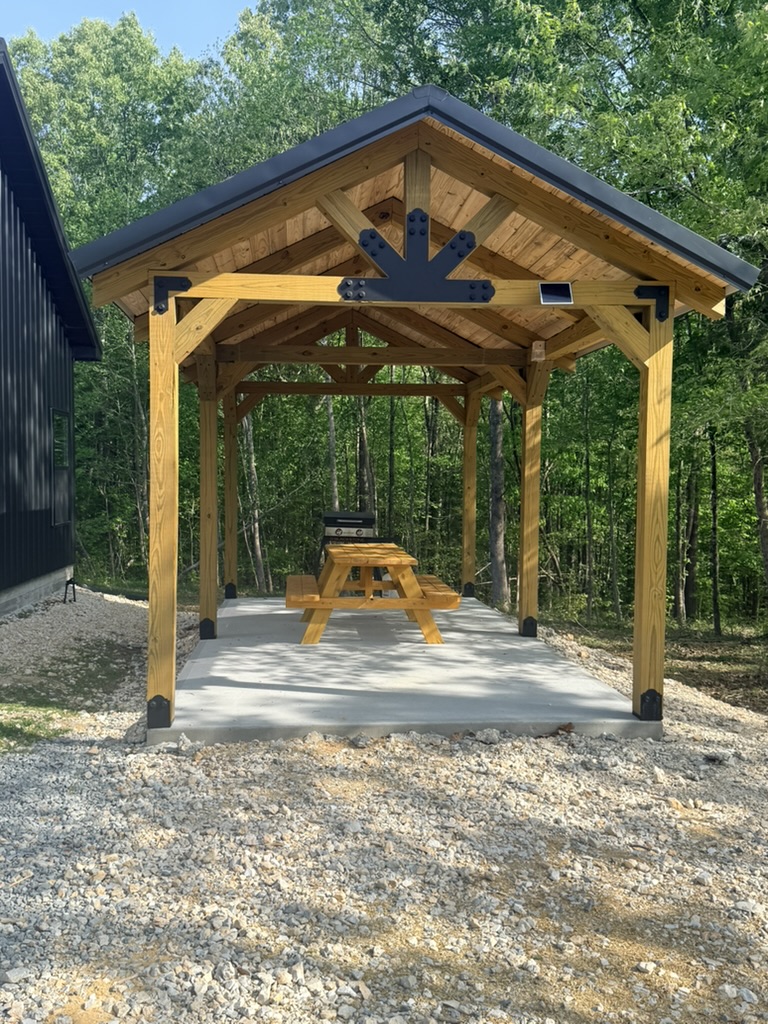 Custom timber-framed covered entrance with exposed wood beams and metal roofing.